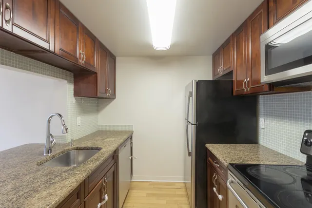 a kitchen with stainless steel appliances granite countertop a sink stove and refrigerator