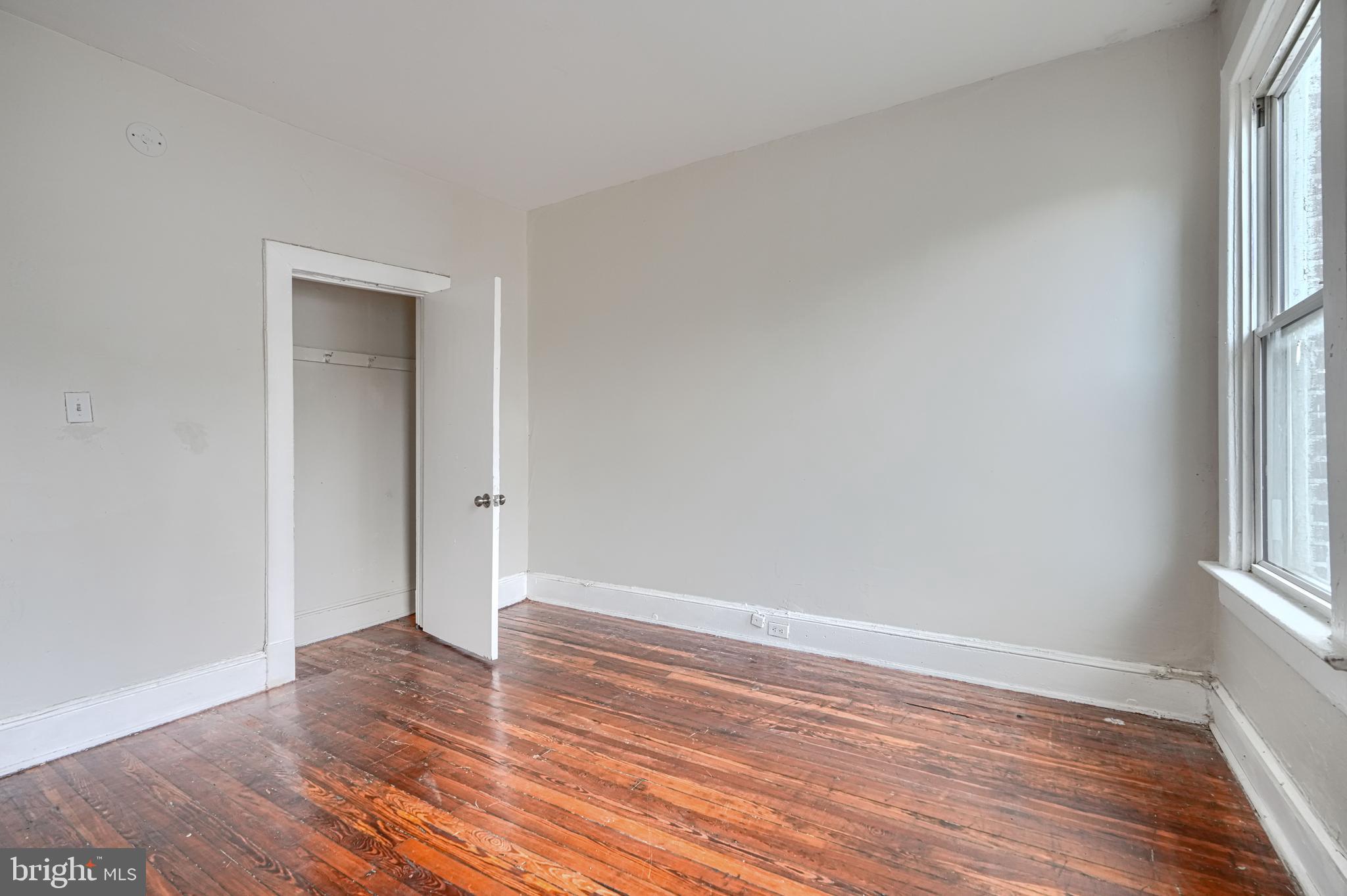 4806 Reisterstown Road Baltimore, MD 21215 - Photo 20 of 34 an empty room with wooden floor and a window