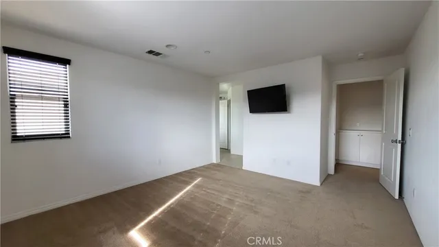 an empty room with windows and a flat screen tv