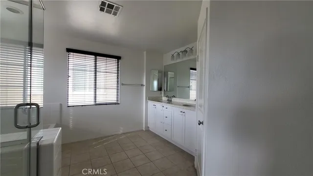 a bathroom with a granite countertop sink mirror and window
