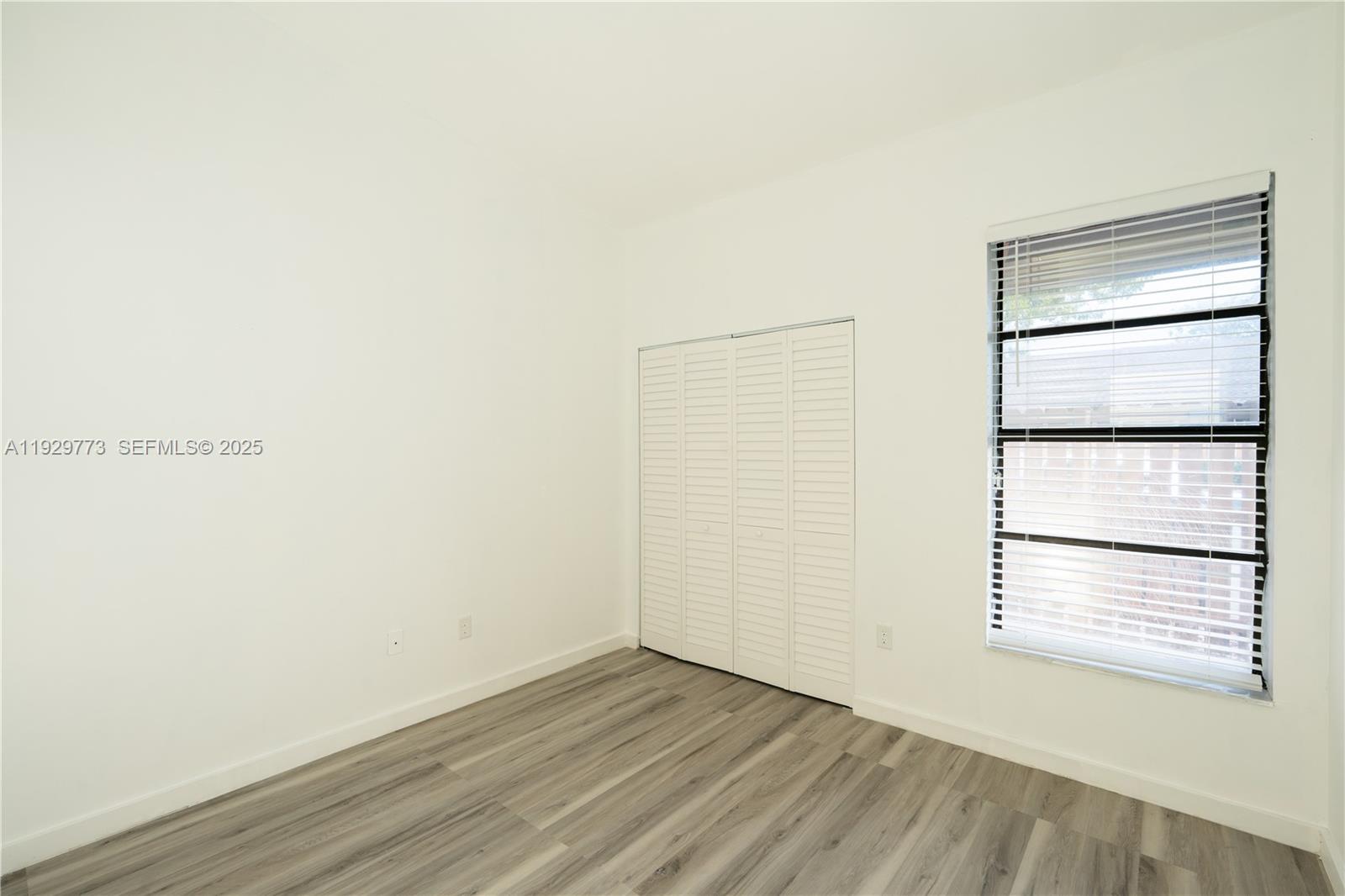 6725 Northwest 192nd Lane Hialeah, FL 33015 - Photo 12 of 29 a view of an empty room with wooden floor and a window
