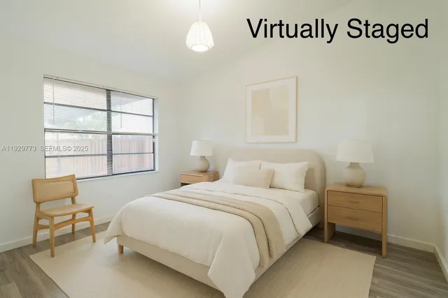 a bedroom with a bed a chair and next to a window