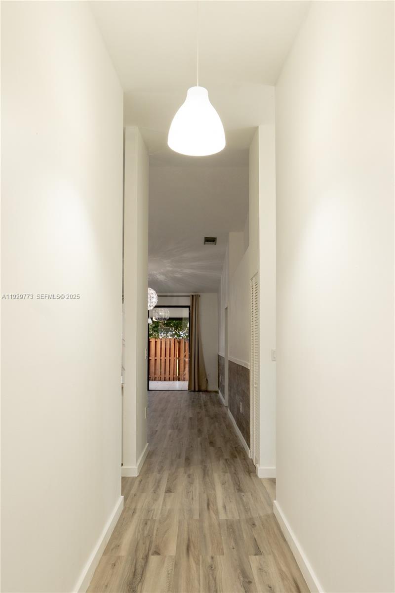 6725 Northwest 192nd Lane Hialeah, FL 33015 - Photo 3 of 29 a view of a hallway with wooden floor and a bathroom