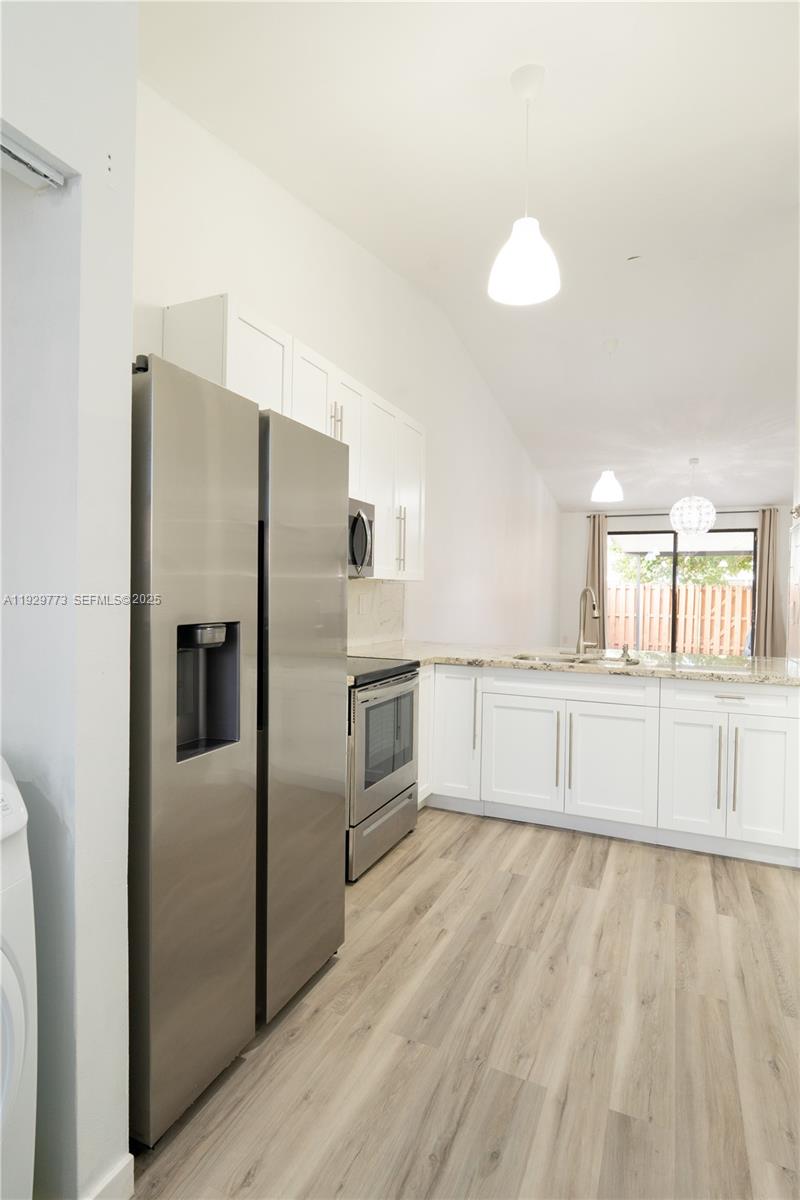 6725 Northwest 192nd Lane Hialeah, FL 33015 - Photo 5 of 29 a kitchen with granite countertop a refrigerator and a sink
