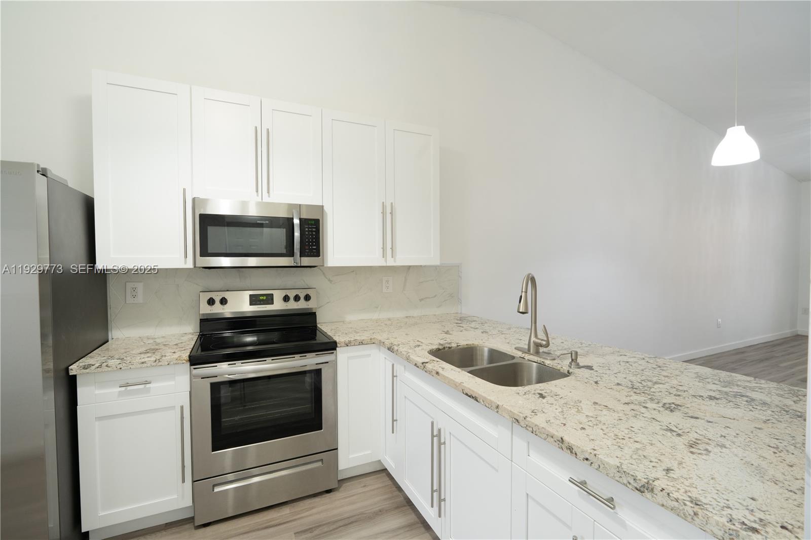 6725 Northwest 192nd Lane Hialeah, FL 33015 - Photo 6 of 29 a kitchen with appliances a sink and cabinets