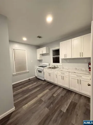 a kitchen with granite countertop white cabinets and white appliances