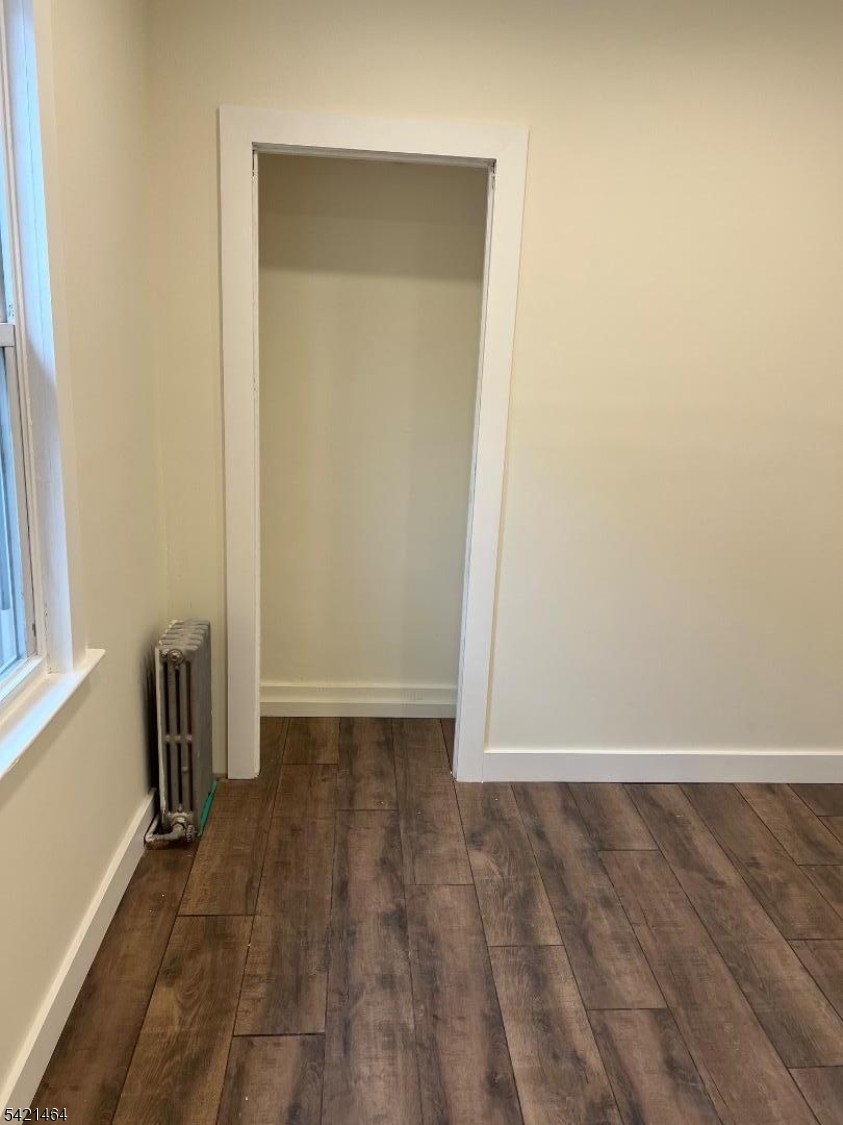 227 Palmer Street, Unit 2 Elizabeth, NJ 07202 - Photo 13 of 13 an empty room with wooden floor and windows