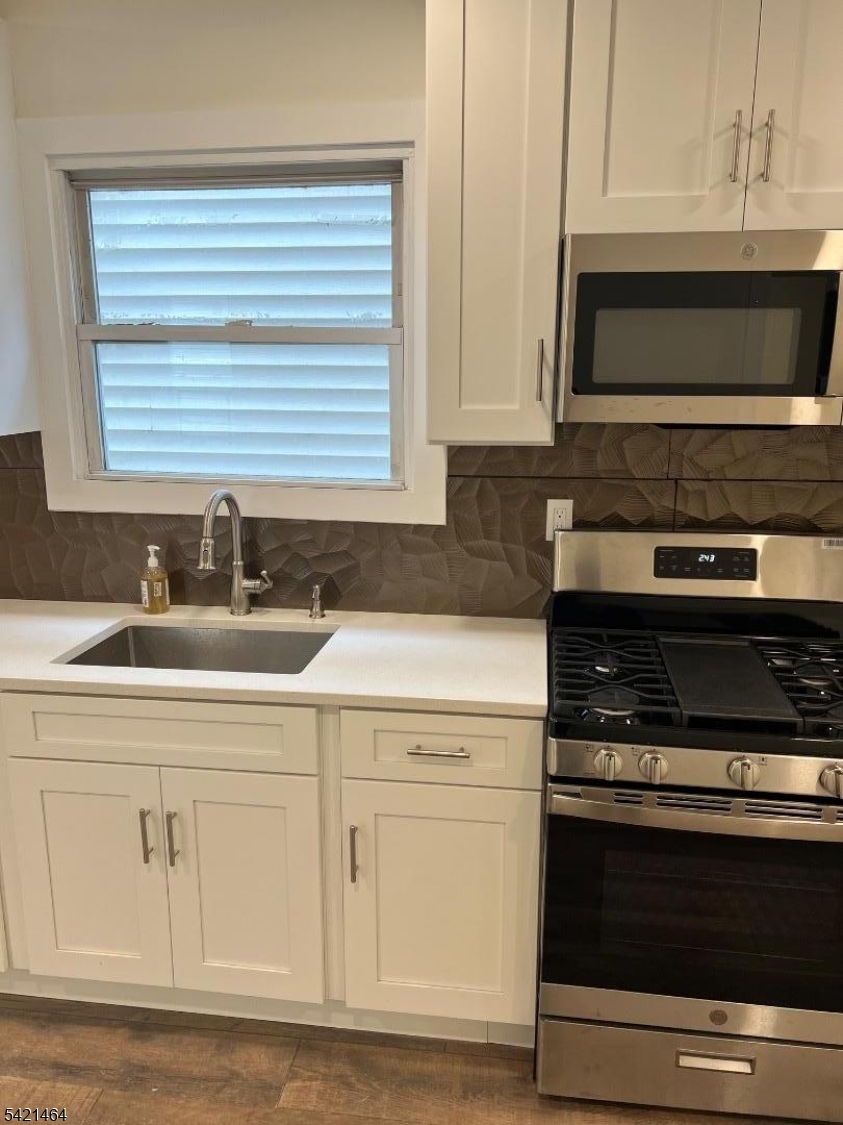 227 Palmer Street, Unit 2 Elizabeth, NJ 07202 - Photo 5 of 13 a kitchen with white cabinets and appliances