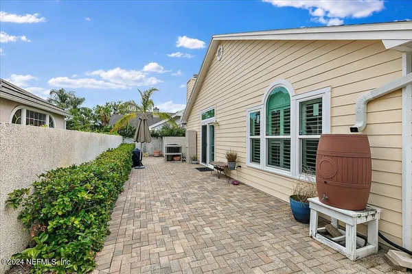 a view of a house with a yard and potted plants