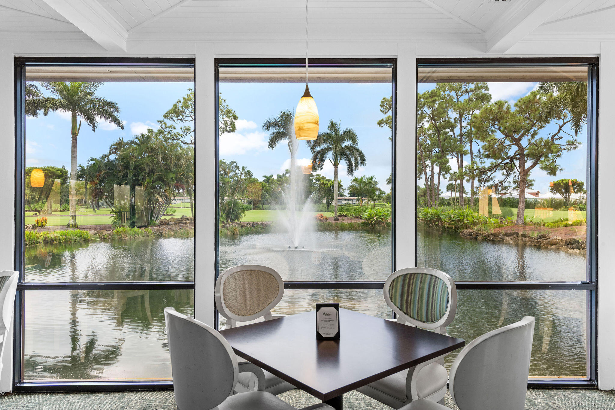 355 Palm Drive, Unit 2 Naples, FL 34112 - Photo 28 of 30 a view of a dining room with furniture a chandelier and wooden floor