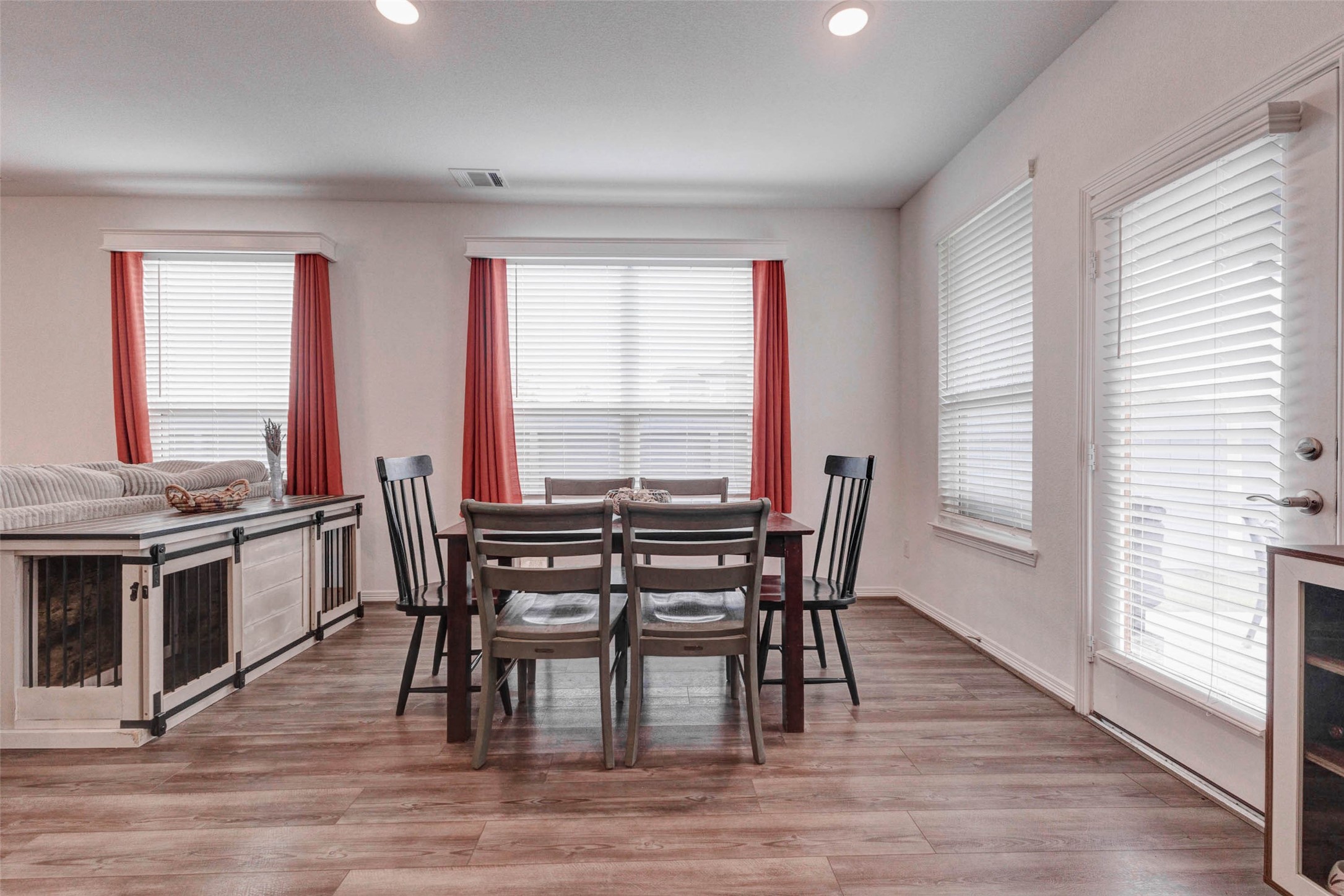 32418 Fly Fish Way Fulshear, TX 77441 - Photo 14 of 40 Another view of the dining area highlights just how bright and airy this space truly is, with large windows along the back wall allowing natural light to pour in throughout the day. The door to the backyard is conveniently accessible right from this space, making it effortless to transition from a dinner gathering to an evening outdoors.