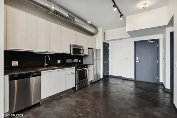 a kitchen with stainless steel appliances a stove a microwave and a hard wood floor