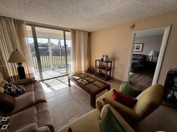 a living room with furniture and a floor to ceiling window