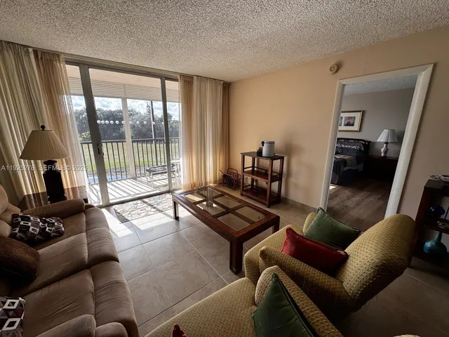 a living room with furniture and a floor to ceiling window