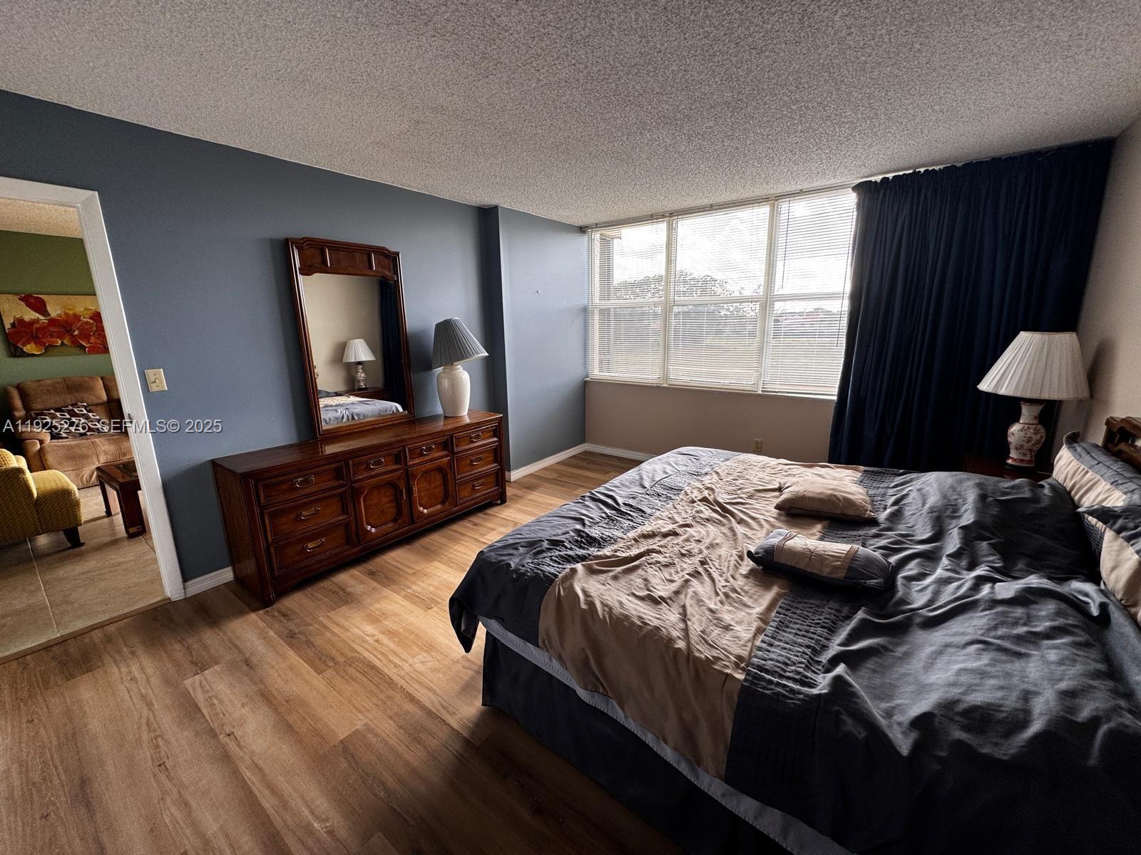 3671 Environ Boulevard, Unit 369 Lauderhill, FL 33319 - Photo 3 of 21 a bedroom with a bed and wooden floor