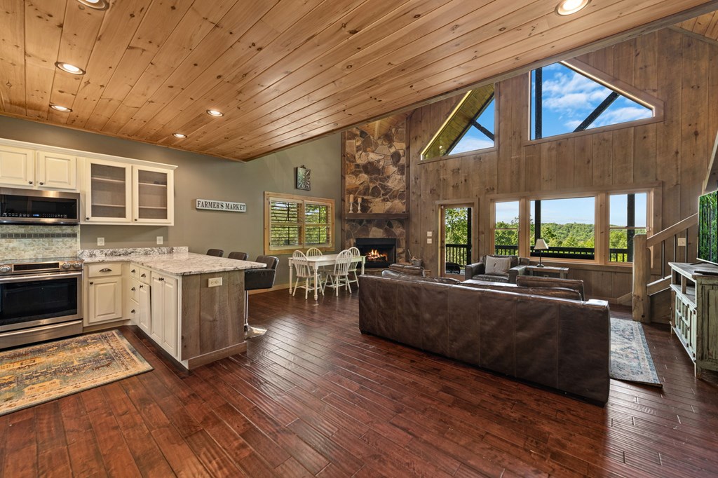 479 Big Timber Road Mineral Bluff, GA 30559 - Photo 10 of 60 a large white kitchen with wooden floors and stainless steel appliances