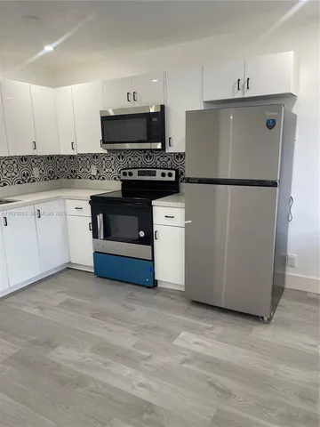 a kitchen with a refrigerator sink and cabinets