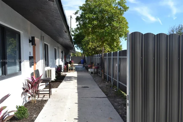 a view of a patio with table and chairs with wooden fence and plants