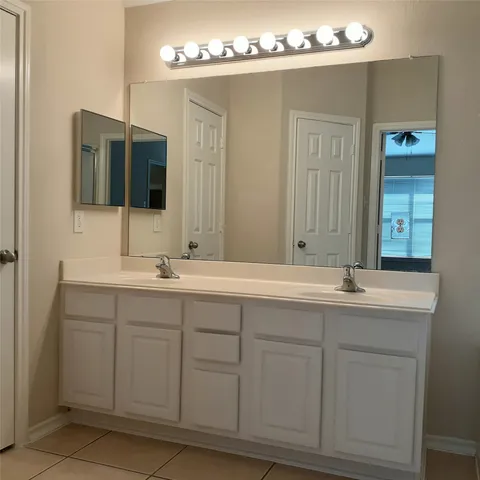 a bathroom with a double vanity sink and mirror