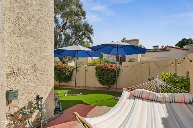 a view of a backyard with a table and chair under an umbrella