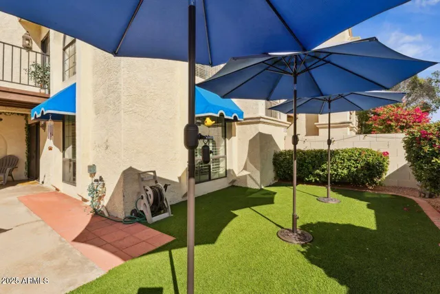 a patio with a table and chairs under an umbrella
