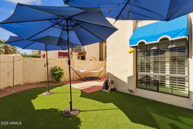 a view of a patio with a table and chairs under an umbrella