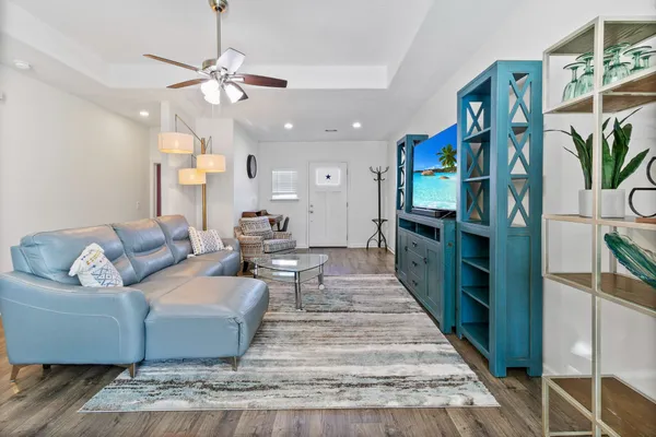 a living room with furniture kitchen view and a chandelier