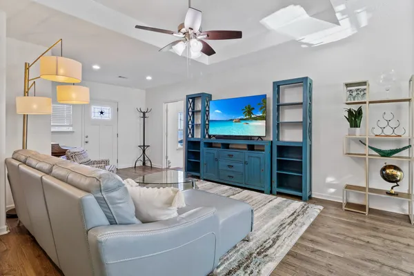 a living room with furniture a flat screen tv and kitchen view