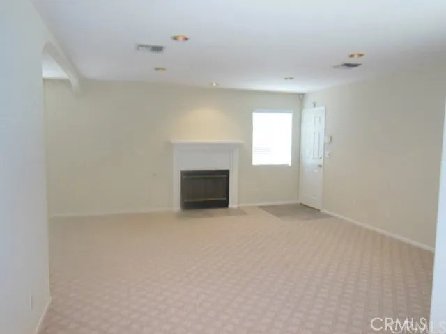 a view of an empty room with closet and mirror