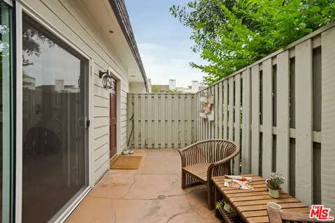 a view of a balcony with furniture and a gate
