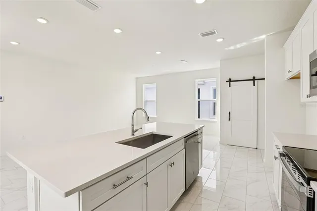 a kitchen with stainless steel appliances granite countertop a sink and a refrigerator