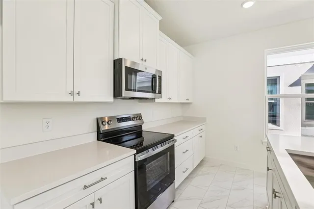 a kitchen with stainless steel appliances granite countertop a sink and a stove
