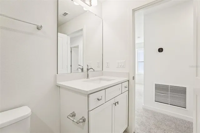 a bathroom with a sink a toilet a mirror and shower