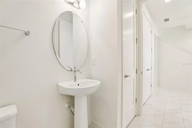 a bathroom with a sink a toilet and a mirror