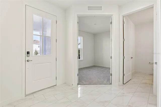 an empty room with window and bathroom