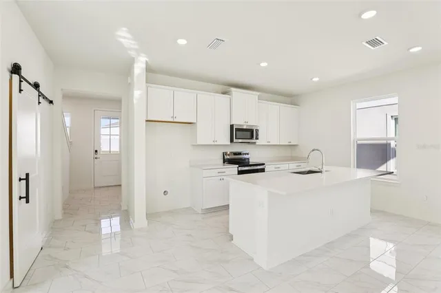 a kitchen with stainless steel appliances a refrigerator sink and cabinets