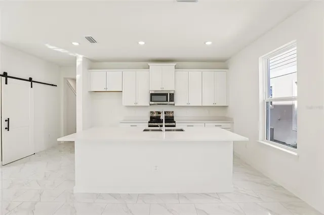 a kitchen with a stove a refrigerator and a sink