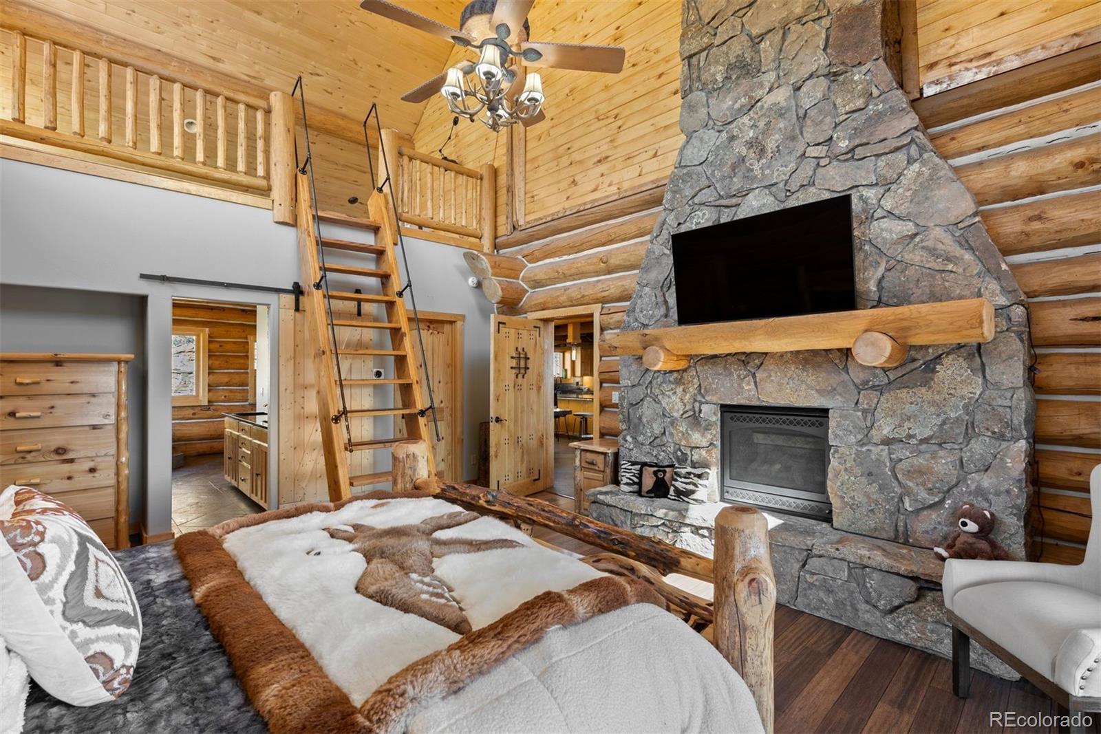 217 North Hill Drive Bailey, CO 80421 - Photo 21 of 49 a bedroom with a bed and a fireplace