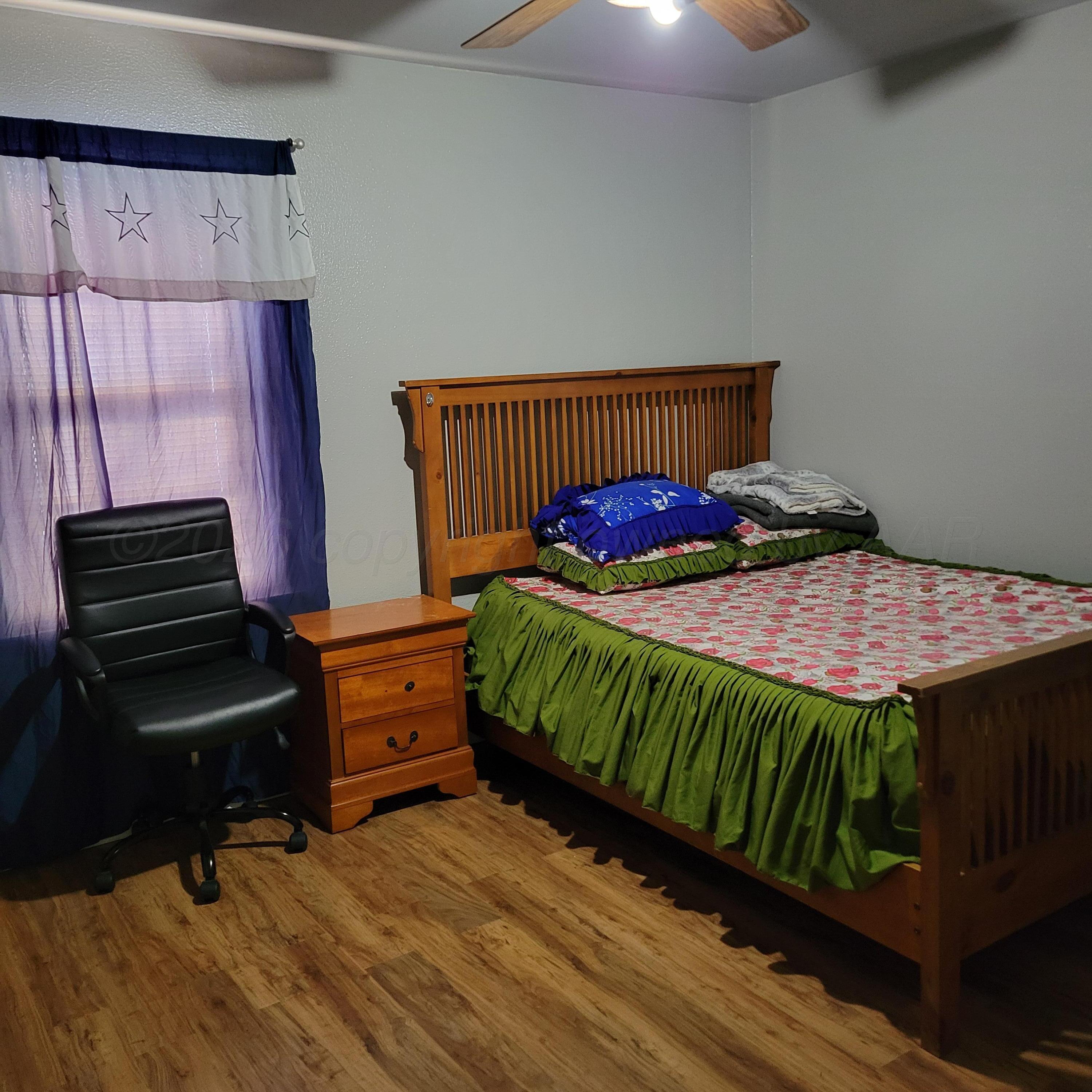 1806 Chama Street Amarillo, TX 79102 - Photo 6 of 15 a bedroom with a bed and wooden floor