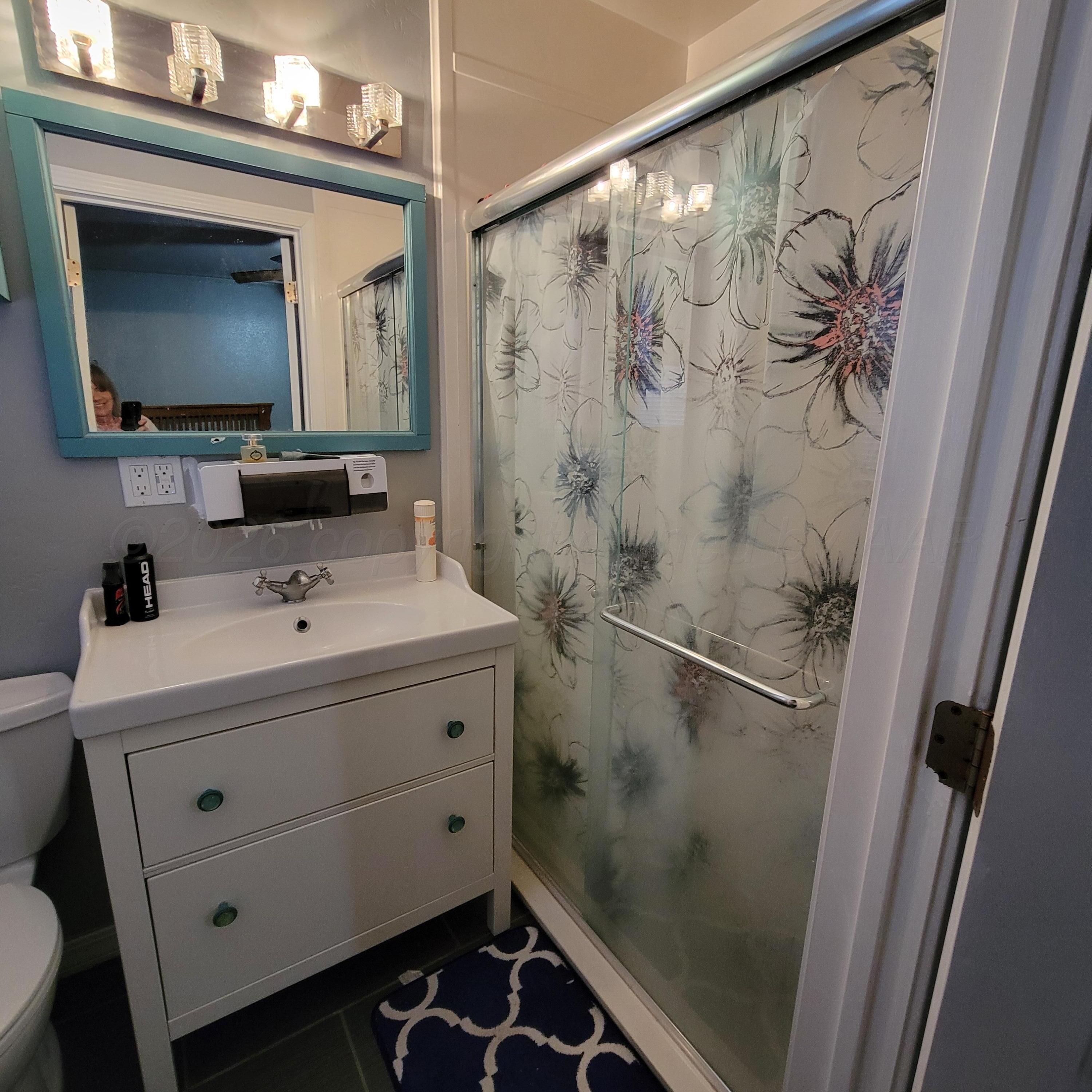 1806 Chama Street Amarillo, TX 79102 - Photo 7 of 15 a bathroom with a sink vanity and a mirror