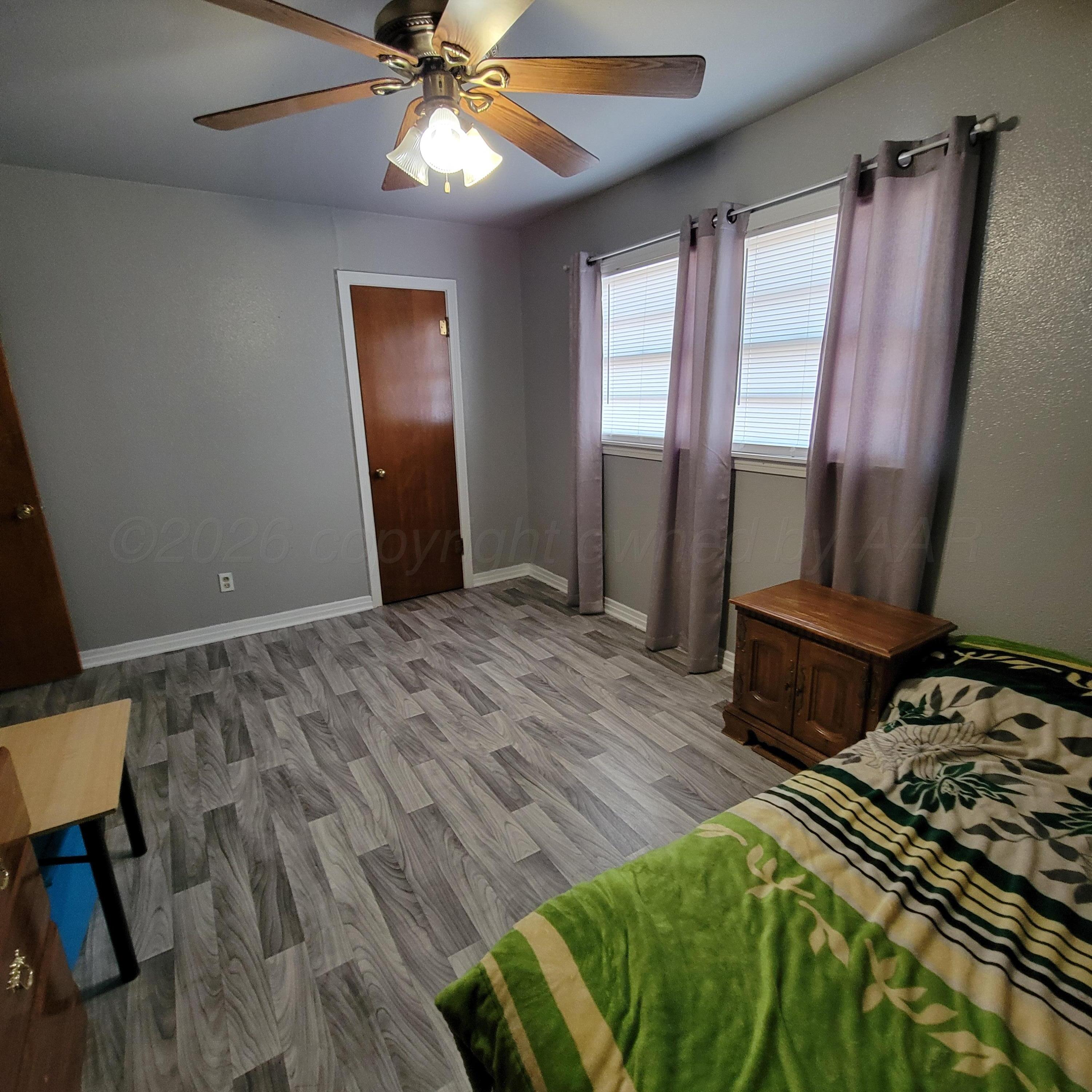 1806 Chama Street Amarillo, TX 79102 - Photo 8 of 15 a bedroom with a bed and wooden floor