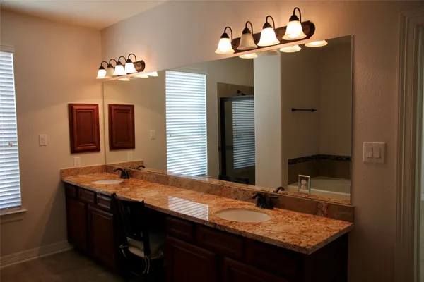 a bathroom with a granite countertop sink and a mirror