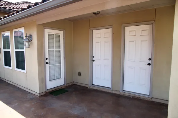 a front view of multi story residential apartment building with yard and sign board