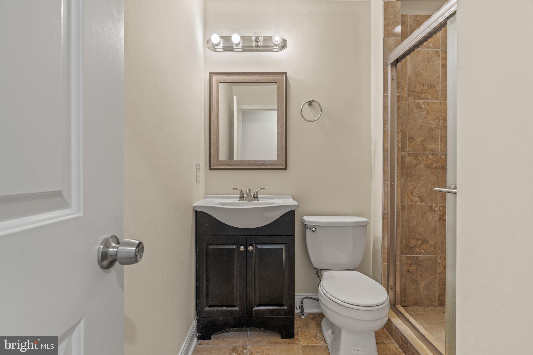 1724 Master Street, Unit C Philadelphia, PA 19121 - Photo 11 of 24 a bathroom with a toilet a sink and mirror