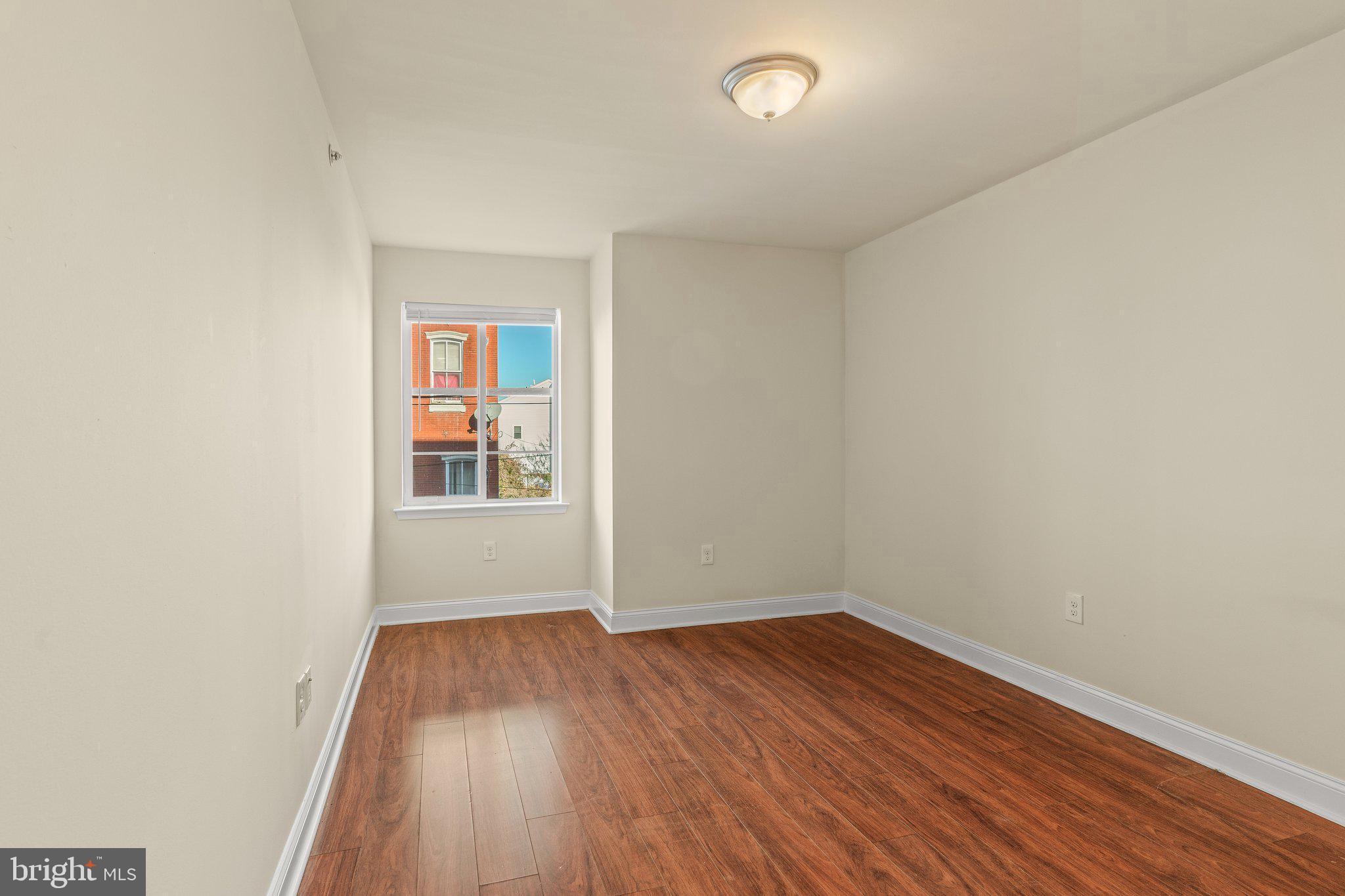 1724 Master Street, Unit C Philadelphia, PA 19121 - Photo 13 of 24 an empty room with wooden floor and windows
