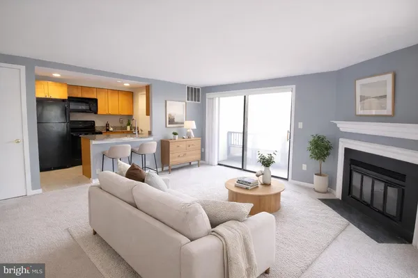 a living room with furniture a fireplace and a large window