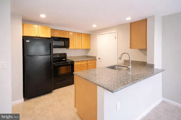 a kitchen with stainless steel appliances granite countertop a sink a refrigerator and a granite counter tops