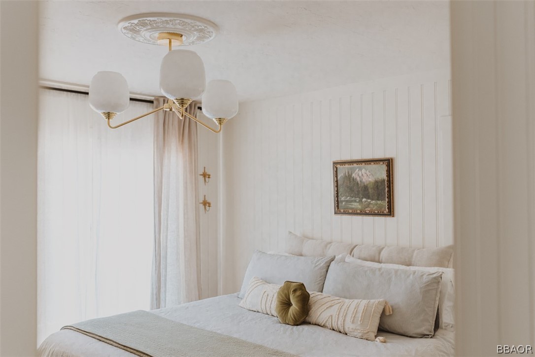 42897 Encino Road Big Bear Lake, CA 92315 - Photo 27 of 45 a bedroom with a bed and a chandelier