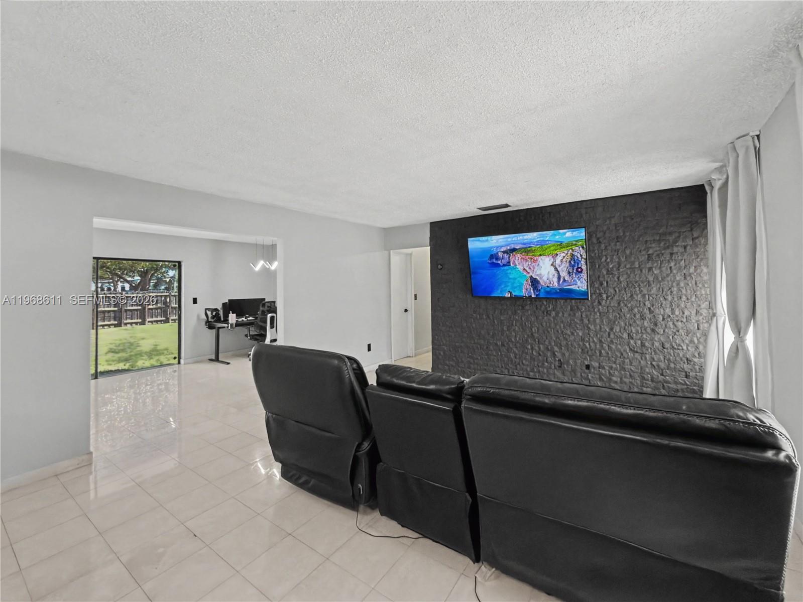 10491 Southwest 122nd Court Miami, FL 33186 - Photo 14 of 25 a living room with furniture and a flat screen tv