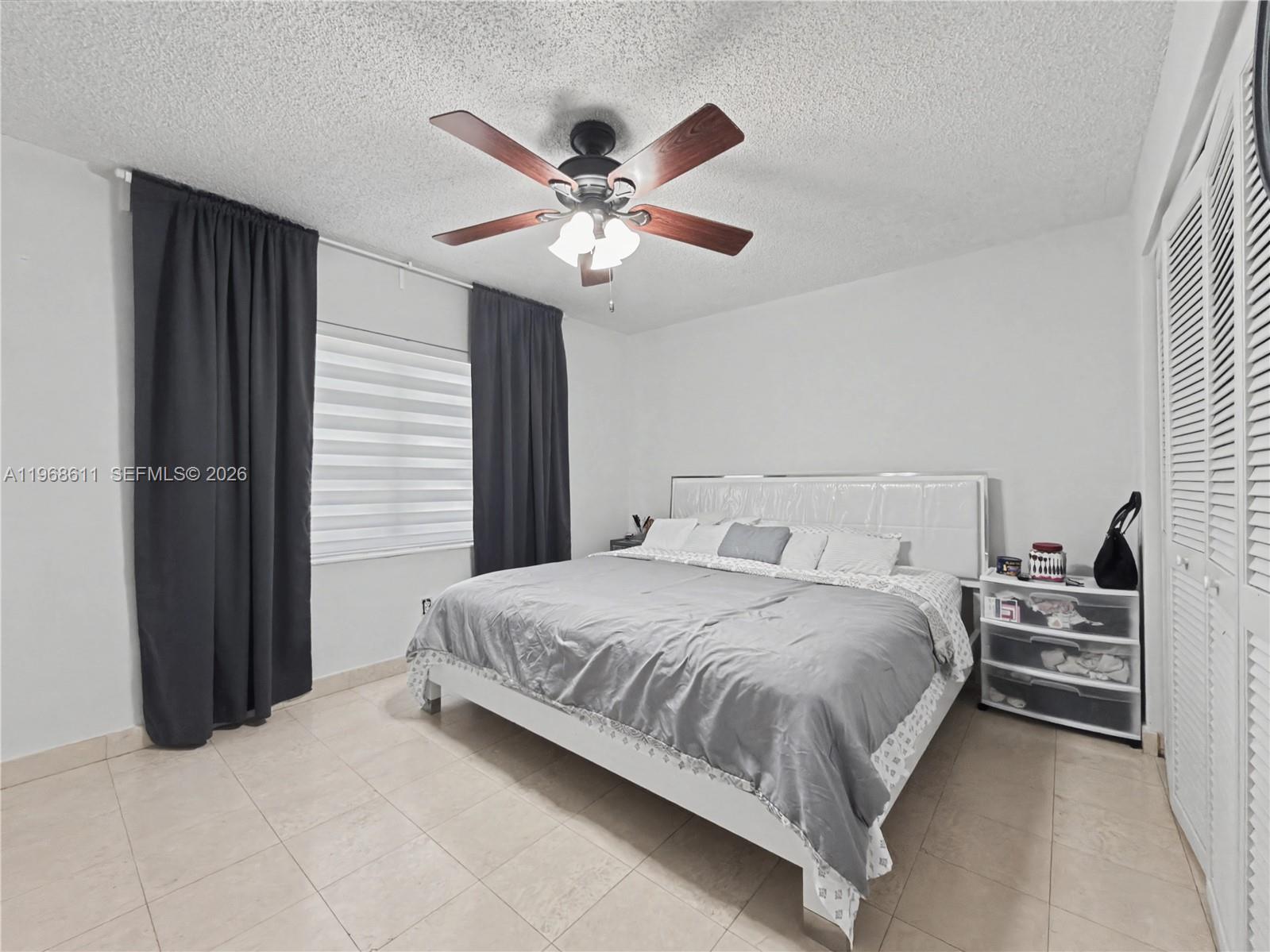 10491 Southwest 122nd Court Miami, FL 33186 - Photo 16 of 25 a bedroom with a bed and a chandelier